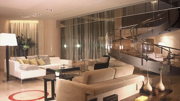 A modern living room with a sofa set, coffee table, and a staircase with glass railings. - Hotel Terrace The Garden Mito (Mito)