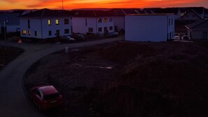 A residential area with houses and a road during sunset.