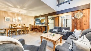 A spacious living area with a dining table, sofas, and a kitchen in the background. - Community Beach Access: Lake Harmony Townhome (Lake Harmony)
