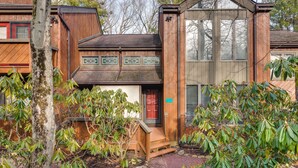 A wooden house with a red door, a small porch, and a window with decorative shutters. - Community Beach Access: Lake Harmony Townhome (Lake Harmony)