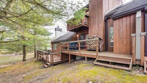 A wooden cabin with a deck, surrounded by trees. - Community Beach Access: Lake Harmony Townhome (Lake Harmony)