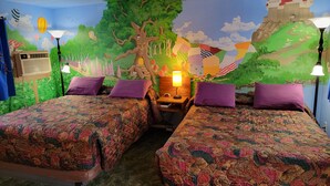 A room with two beds, a nightstand with a lamp, and a mural of a castle and tree. - La Collage Inn (Odessa)