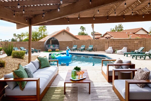An outdoor patio with a pool, lounge chairs, and a covered seating area. - Resort Backyard: Heated Pool, Hot Tub, Fire Table, EV, 3 Primaries (Scottsdale)
