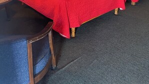 Een hotelkamer met twee bedden, een tafeltje en een lamp.