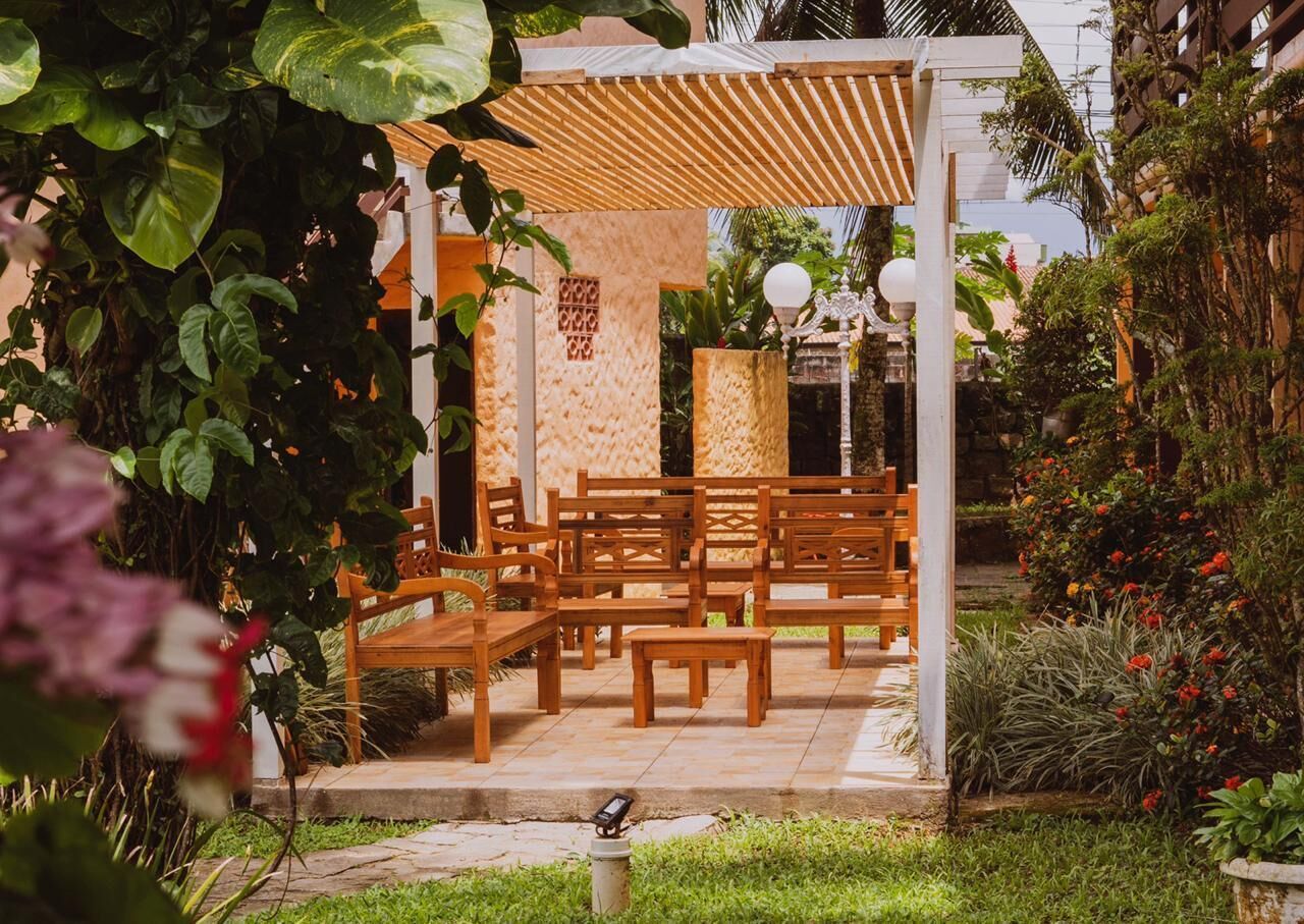 A covered outdoor seating area with wooden benches and a pergola structure.