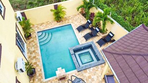 A rooftop pool area with a hot tub, lounge chairs, and potted plants. - Cozy Luxury Hideaway With Free Wifi,Parking,Swimming Pool&Jacuzzi Near Negril 1b (Green Island)