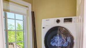 A laundry room with two Samsung washing machines, a window, and a sink. - Cozy Luxury Hideaway With Free Wifi,Parking,Swimming Pool&Jacuzzi Near Negril 1b (Green Island)