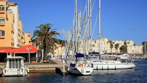 A marina with several sailboats docked, a palm tree, and buildings with balconies. - Lovely home in Saint-Laurent-de-la-Ca with WiFi (Saint-Laurent-de-la-Ca)