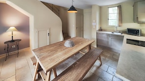A kitchen with a wooden table, bench, and a hanging light fixture. - Lovely home in Saint-Laurent-de-la-Ca with WiFi (Saint-Laurent-de-la-Ca)