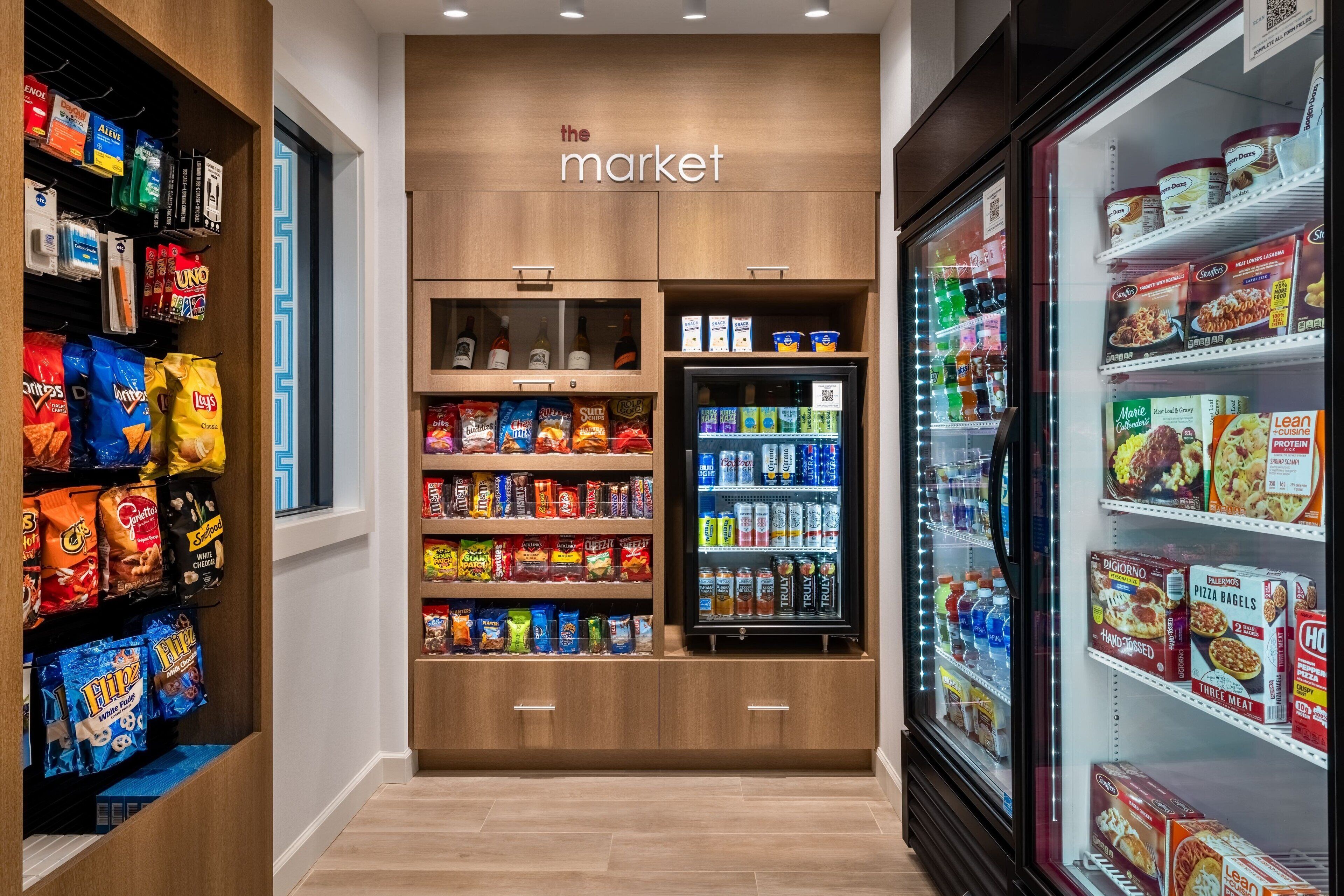 A grocery store aisle with shelves stocked with snacks, beverages, and frozen foods.