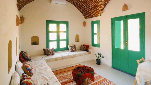 A room with a brick ceiling, green doors, and a sofa with colorful pillows. - Bangalow Chebba (LA CHEBBA)