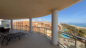Un balcon donnant sur une zone côtière, avec vue sur des bâtiments et une plage.