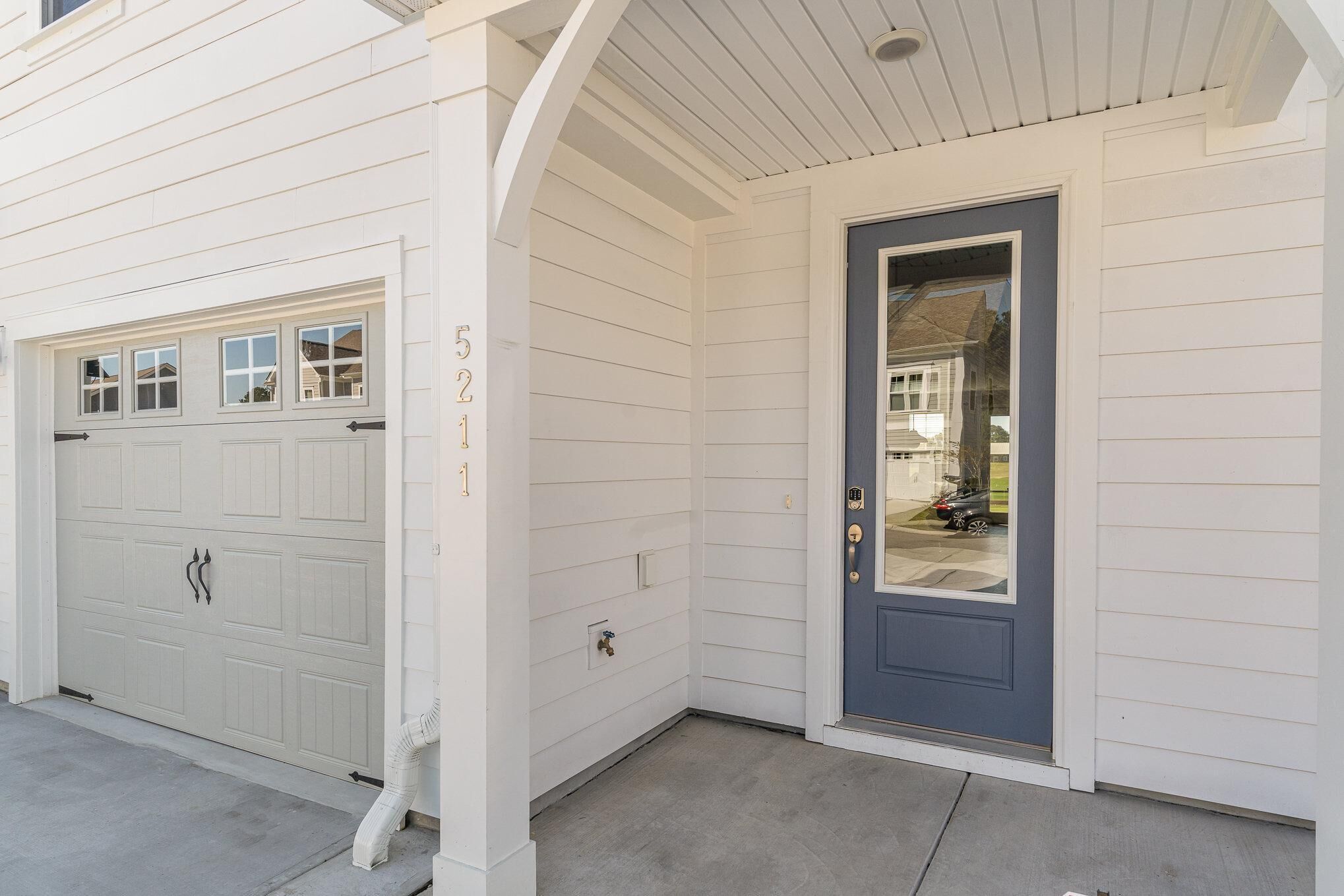 A white house with a garage and a blue front door.