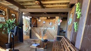 Een ontvangstgebied met houten banken, een receptiebalie en een muur met een visgraatmotief.