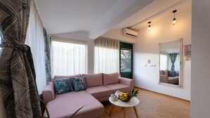 A living room with a sofa, a small round table with a fruit bowl, and a large mirror on the wall. - Stunning home in Kastel Novi (Kastel Novi)