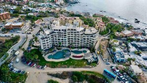 Un hotel a più piani con cortile interno, piscina e vista sulla spiaggia.