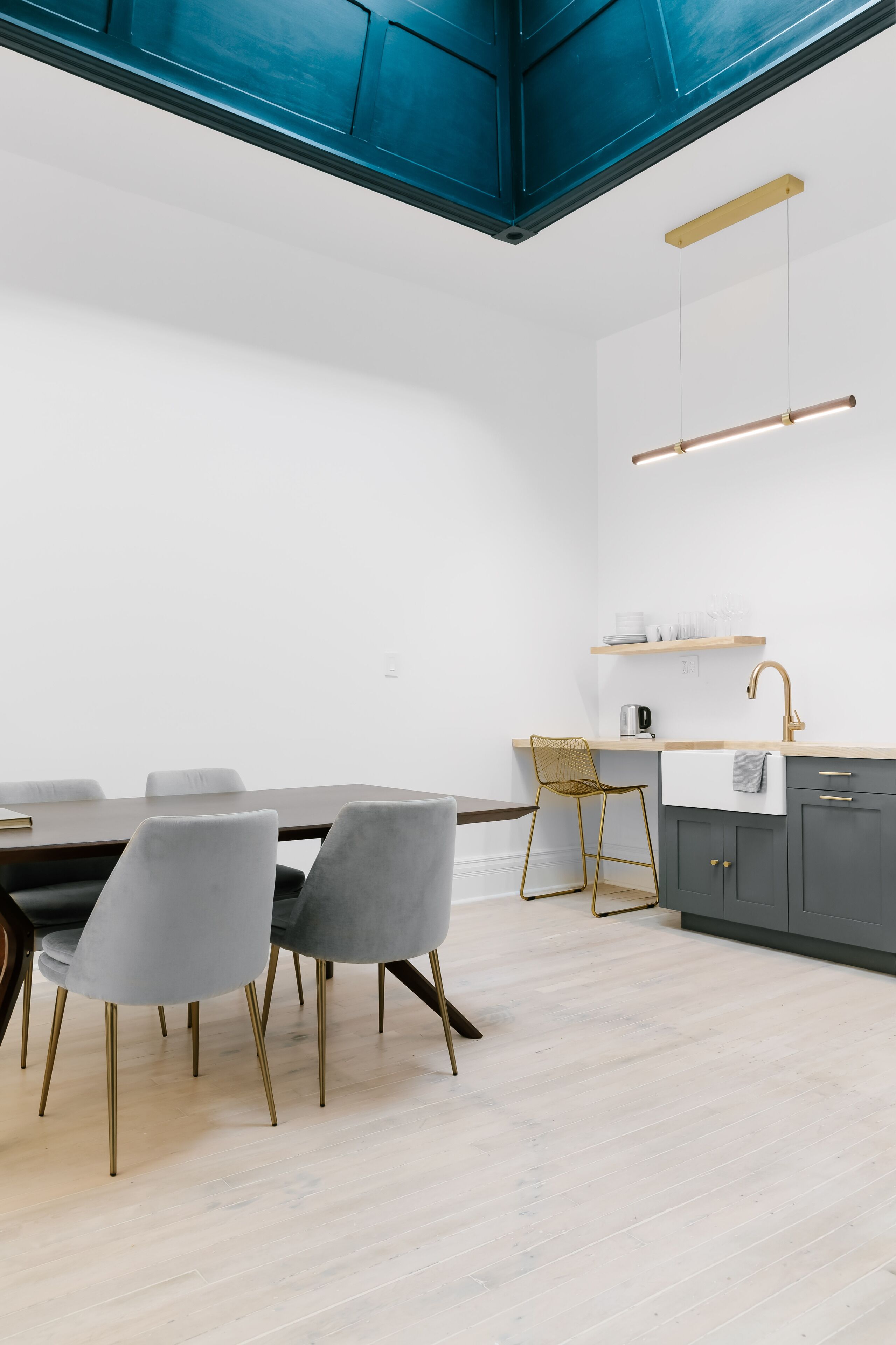 Una cocina moderna con encimera de madera, un lavamanos y una lámpara colgante.