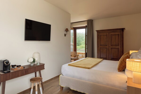A bedroom with a bed, a desk, a television, and a view of the outdoors. - Poggio Paradiso Resort & Spa (Torrita di Siena)
