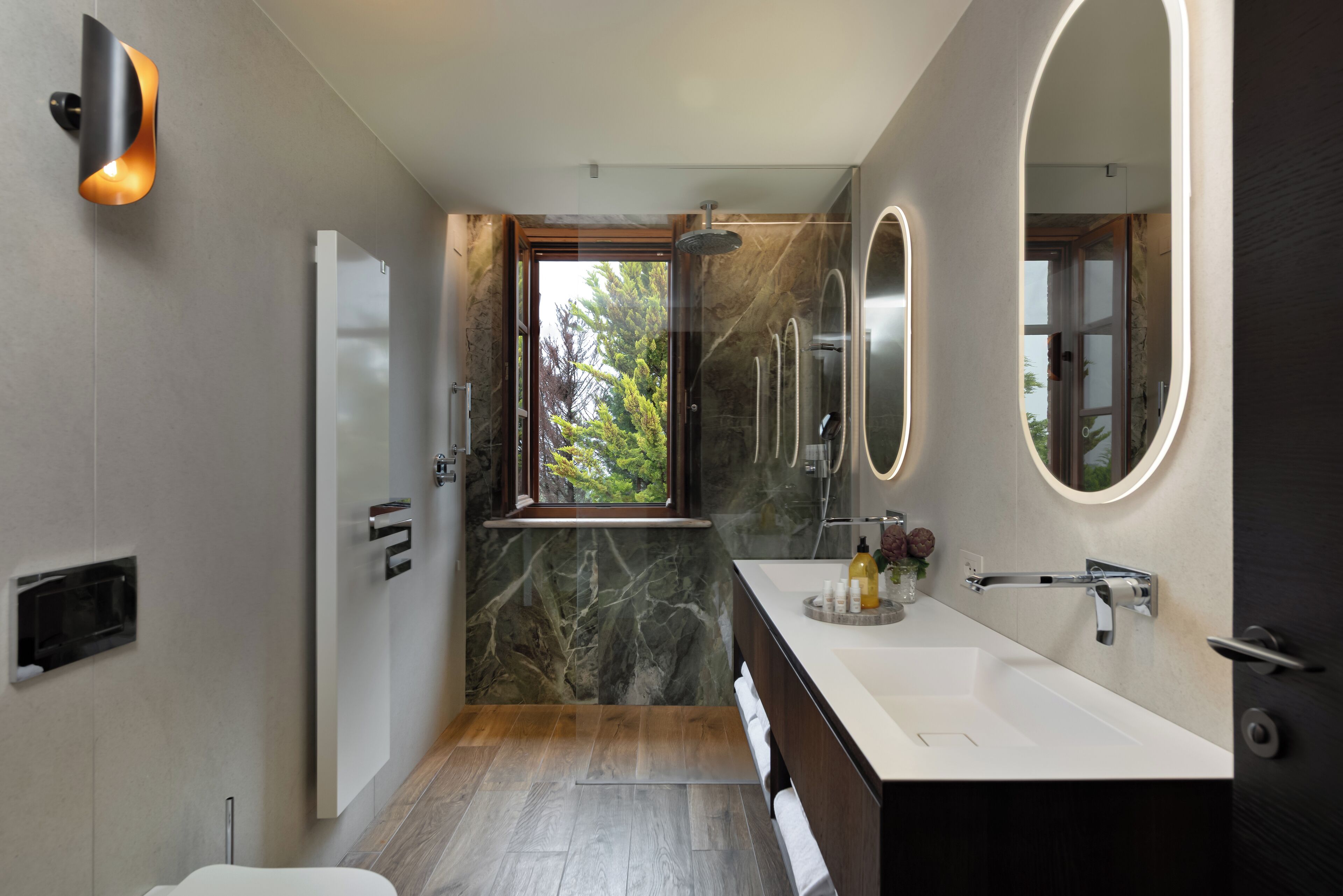 Un bagno moderno con un grande specchio, una doccia e un mobile lavabo.