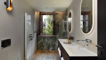 Un bagno moderno con un grande specchio, una doccia e un mobile lavabo.