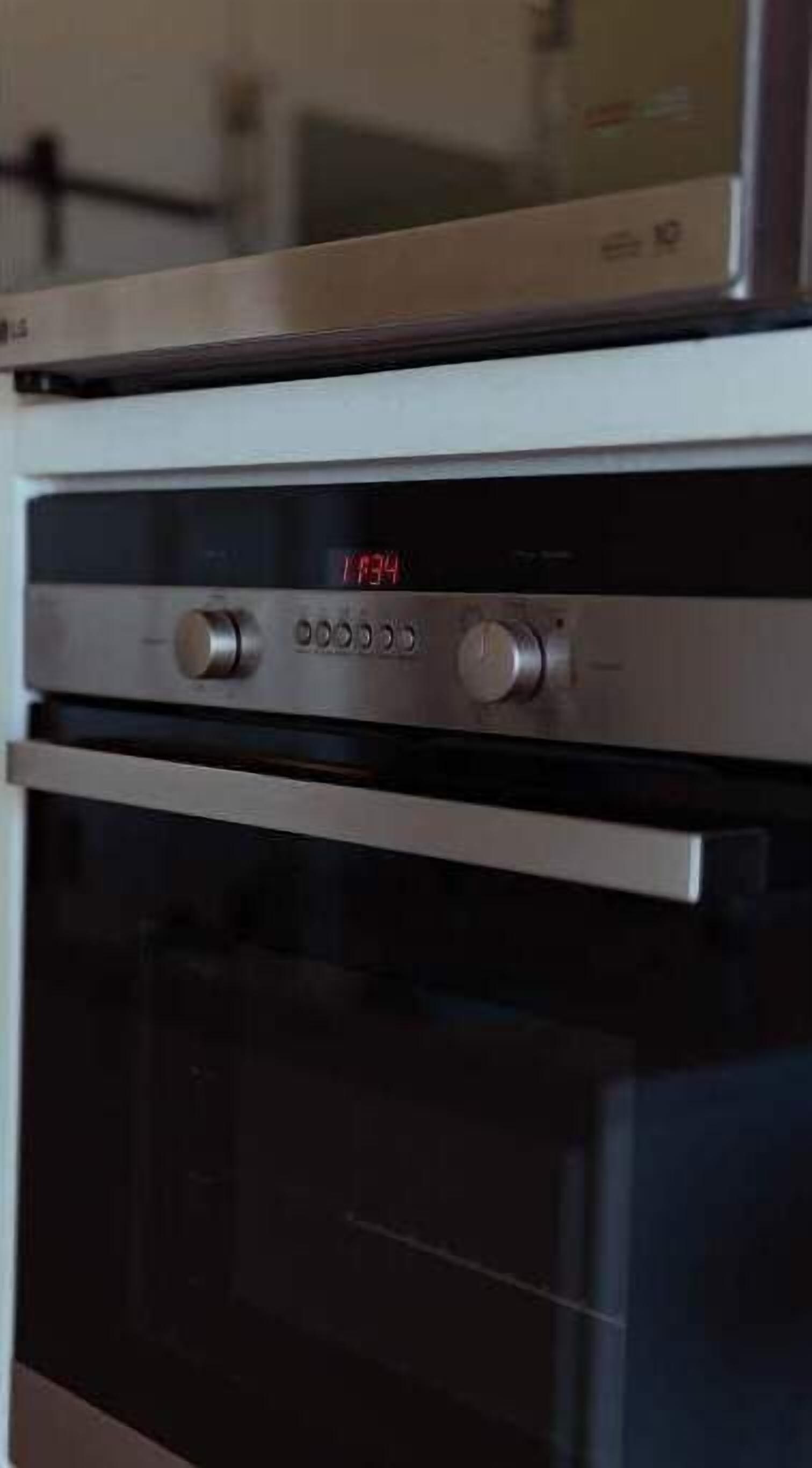 A kitchen with a built-in oven and microwave.