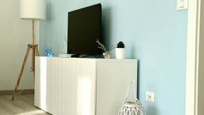 A room with a white cabinet, a television on top, a floor lamp, a small plant, and a decorative item. - M379 - Marcelli, renovated three-room apartment with terrace overlooking the sea (Marcelli)