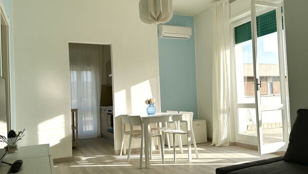 A modern living room with a dining area, a sofa, and a view of the outside. - M379 - Marcelli, renovated three-room apartment with terrace overlooking the sea (Marcelli)