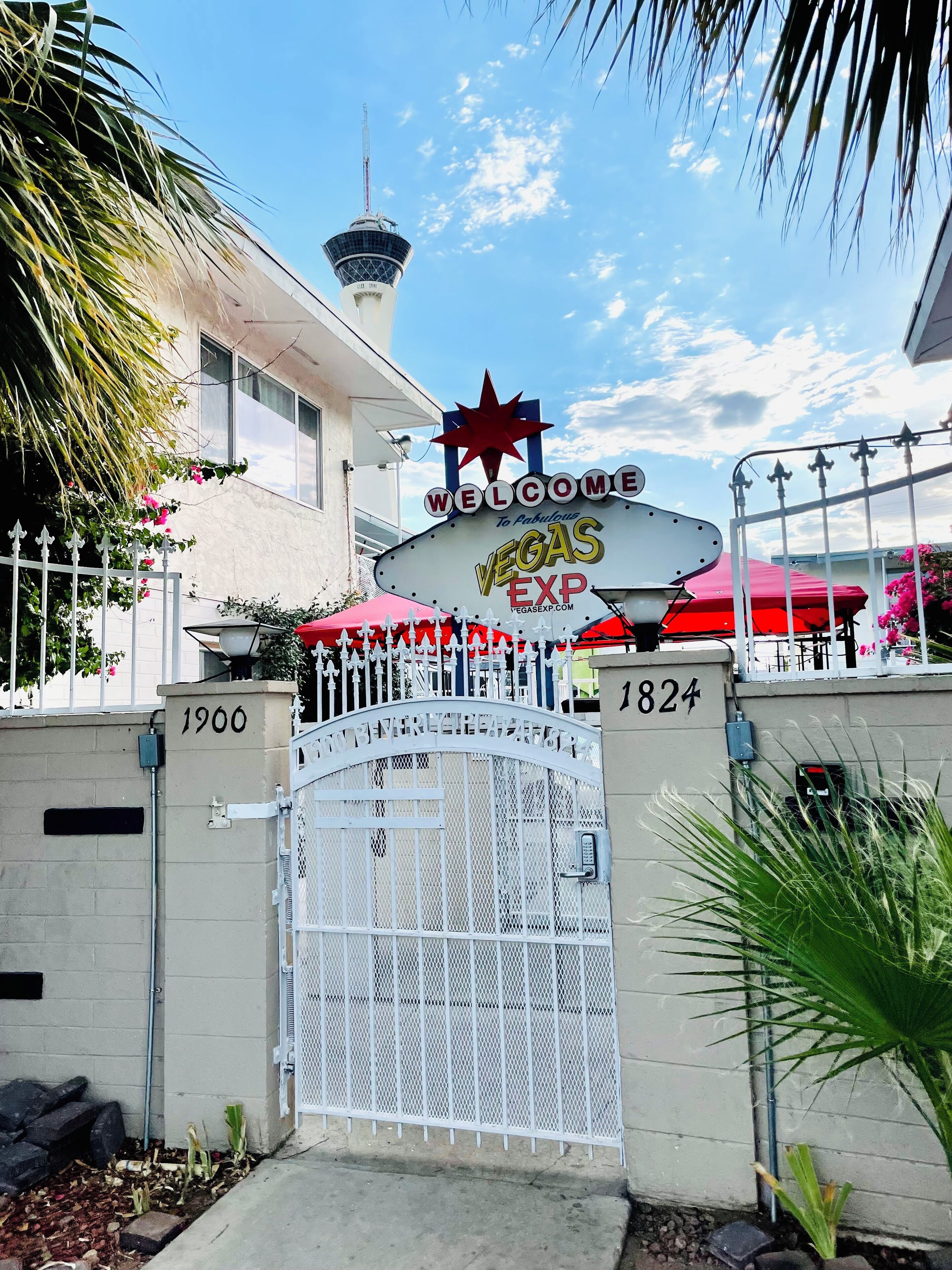 Une entrée fermée par un portail, sur laquelle on peut lire l’inscription « Bienvenue à Las Vegas », ainsi qu’une étoile rouge et les adresses « 1900 » et « 1824 ».
