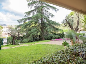 Stroll through the beautifully maintained garden, featuring a variety of trees and flowering plants.