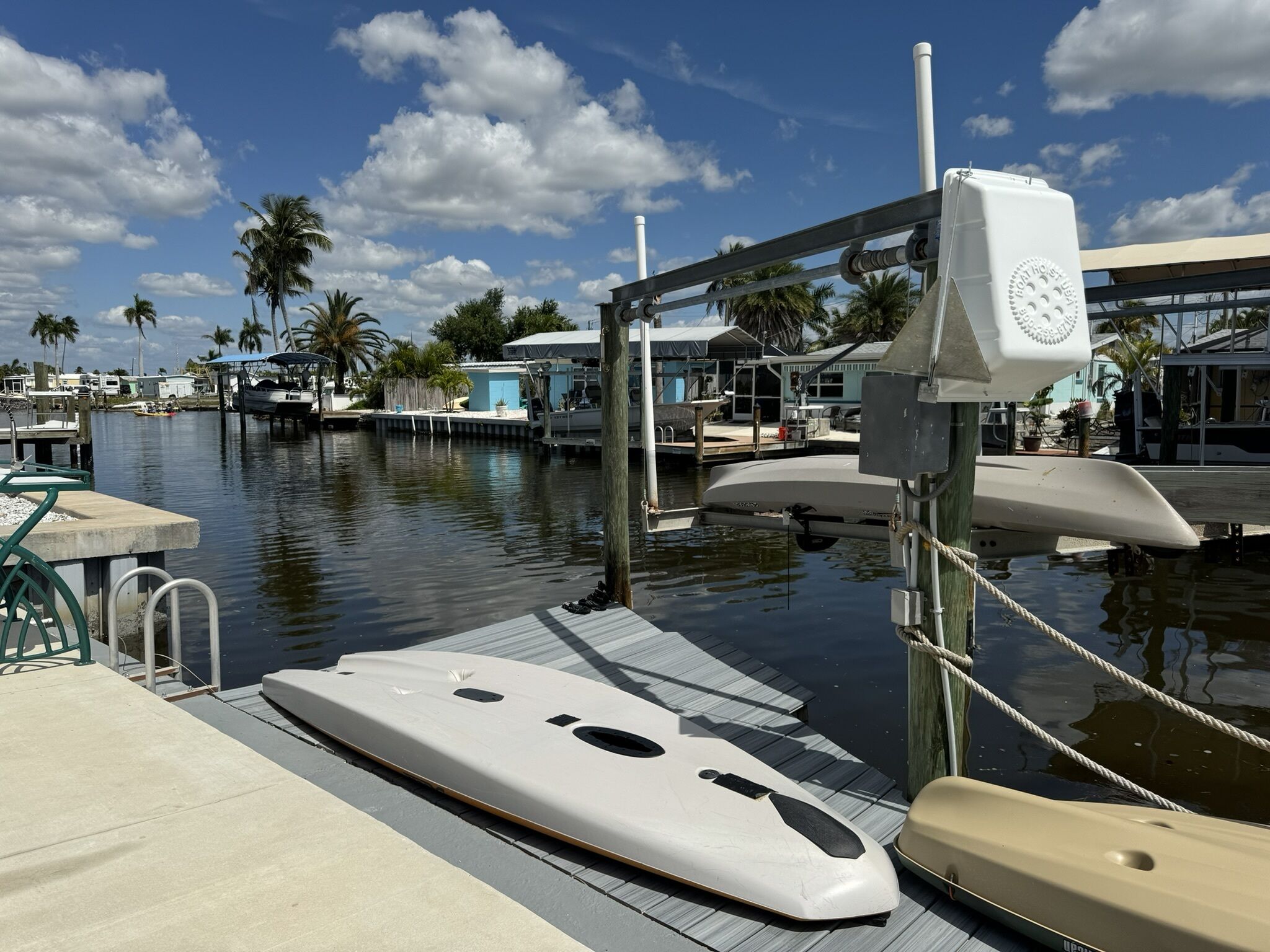 A marina with boats docked, a wooden dock, and a clear blue sky.