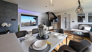 A modern living room with a dining area, a staircase, and a view of the city. - Lovely home in Vinogradi Ludbreski with sauna (Vinogradi Ludbreski)