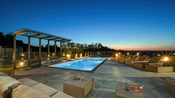 A rooftop pool area with a glass enclosure, lounge chairs, and a dining table with drinks. - Lovely home in Vinogradi Ludbreski with sauna (Vinogradi Ludbreski)