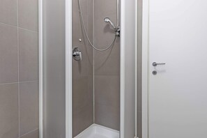 A shower with a handheld showerhead and a wall-mounted faucet. - Vivaldi Home - Immobili e Soluzioni Rent (Bergamo)