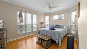 A bedroom with a bed, a ceiling fan, and large windows. - Quaint and Cozy Lake Norman Condo Lakefront Walkable Dogs Ok (Davidson)