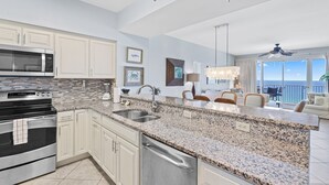 A modern kitchen with granite countertops, stainless steel appliances, and a large island.