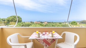 A balcony with a table set for two, overlooking a scenic landscape. - Apartment 'Lotus 5' with Sea View, Wi-Fi and Air Conditioning (Corfu)
