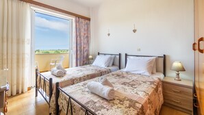 A hotel room with two beds, a balcony, a wooden dresser, and a nightstand with a lamp. - Apartment 'Lotus 5' with Sea View, Wi-Fi and Air Conditioning (Corfu)
