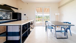 Een moderne keuken met een inbouwfornuis, een zwarte afzuigkap en een betegelde achterwand.