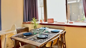 A dining table set with plates, glasses, and a plant.