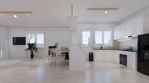 Una cocina moderna con armarios blancos, un refrigerador negro y un comedor con mesa y sillas.