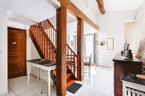 A staircase with wooden railings, a white door, and a tiled floor.