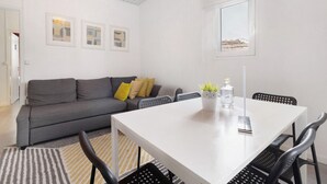 A modern living room with a white table, grey sofa, and black chairs. - Apartment 'Prestigegoldresidence 2 - Old Town' with Balcony, Wi-Fi and Air Conditioning (Guimarães)