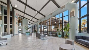 A spacious lobby with high ceilings, large windows, and modern seating areas.