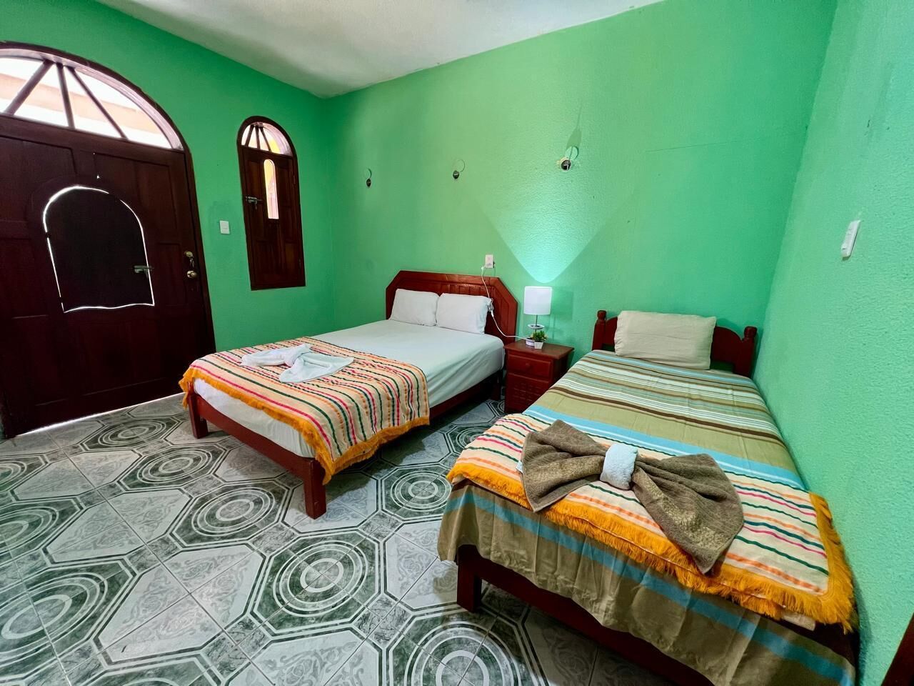 Een kamer met twee bedden, een deur en een raam.