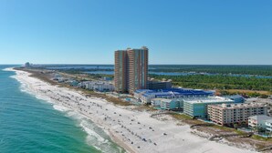 A coastal hotel with multiple buildings, a beach, and a clear view of the ocean. - BEACHFRONT, FAMILY FRIENDLY, LOW FLOOR, OUTDOOR POOL (Orange Beach)