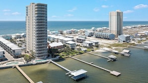 A coastal hotel area with high-rise buildings, a marina, and a clear view of the ocean. - WATERFRONT LOW DENSITY CONDO, BEACH ACCESS, INDOOR/OUTDOOR POOLS (Gulf Shores)