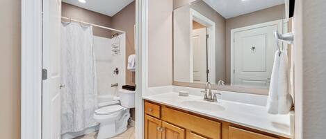 Une salle de bain moderne avec un lavabo blanc, un meuble-lavabo en bois et un grand miroir.
