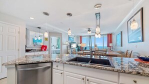 A modern kitchen with granite countertops, stainless steel appliances, and pendant lighting. - BEACHFRONT, FAMILY FRIENDLY, OUTDOOR POOL, CLOSE TO RESTAURANTS (Gulf Shores)