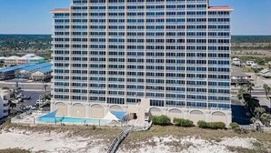 A multi-story hotel with a pool area in the foreground. - BEACHFRONT, FAMILY FRIENDLY, OUTDOOR POOL, CLOSE TO RESTAURANTS (Gulf Shores)