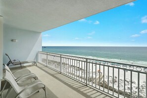 Un balcon avec vue sur la plage et l’océan.